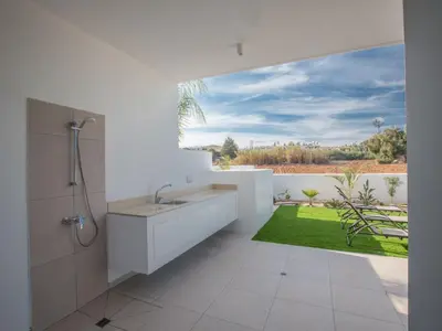 a bathroom with a sink and a view of a yard at Holiday Home 3-Schlafzimmer-Villa mit privatem Pool im Zentrum by Interhome in Protaras