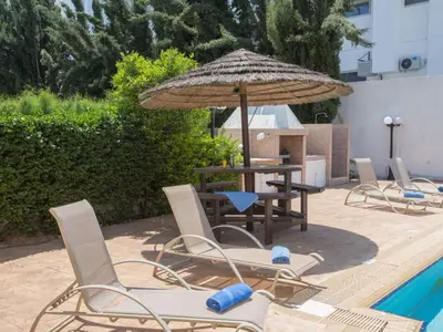 a patio with a table and chairs and an umbrella at Holiday Home in Protaras mit privatem Parkplatz by Interhome in Protaras