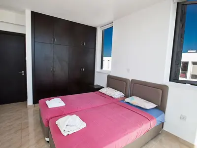 a bedroom with a pink bed with two towels on it at Holiday Home Protaras Perle Villa PE15 by Interhome in Protaras