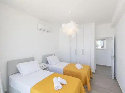 two beds in a room with yellow and white at Holiday Home Protaras Olivine Villa OL9 by Interhome in Protaras