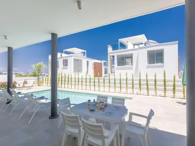 a patio with a table and chairs and a house at Holiday Home Protaras Olivine Villa OL9 by Interhome in Protaras