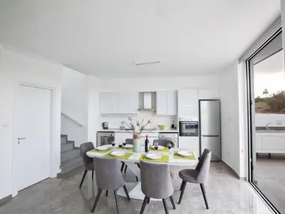 a kitchen and dining room with a table and chairs at Holiday Home 2-Schlafzimmer-Villa mit Pool- Dachgarten- Meerblick by Interhome in Protaras