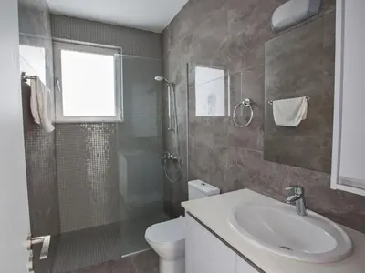 a bathroom with a sink and a shower and a toilet at Holiday Home 2-Schlafzimmer-Villa mit Pool- Dachgarten- Meerblick by Interhome in Protaras