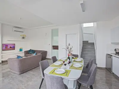 a dining room and living room with a table and chairs at Holiday Home 2-Schlafzimmer-Villa mit Pool- Dachgarten- Meerblick by Interhome in Protaras