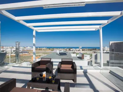 a patio with chairs and tables on a roof at Holiday Home Protaras Olivine Villa mit Pool und einem Dachgarten by Interhome in Protaras