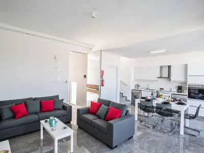 a living room with two black couches and red pillows at Holiday Home Protaras Olivine Villa mit Pool und einem Dachgarten by Interhome in Protaras