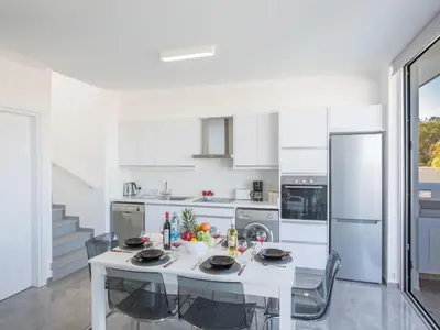 a white kitchen with a white table and appliances at Holiday Home Protaras Olivine Villa mit Pool und einem Dachgarten by Interhome in Protaras