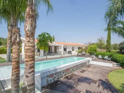 a swimming pool with palm trees and a house at Holiday Home 4-Schlafzimmer-Villa mit Pool im Zentrum von Protaras by Interhome in Protaras