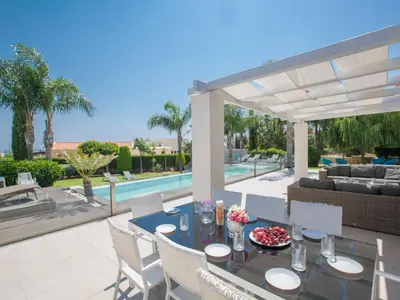 a patio with a table and chairs and a pool at Holiday Home 4-Schlafzimmer-Villa mit Pool im Zentrum von Protaras by Interhome in Protaras