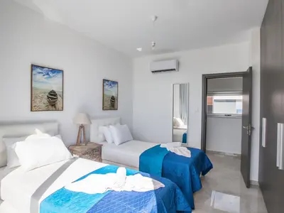 a hotel room with two beds and a couch at Holiday Home 3-Schlafzimmer-Villa mit privatem Pool im Zentrum by Interhome in Protaras