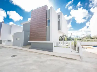 a white house with a wooden wall at Holiday Home 3-Schlafzimmer-Villa mit privatem Pool im Zentrum by Interhome in Protaras
