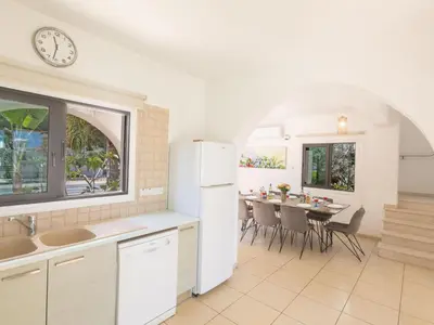a kitchen and dining room with a table and a clock at Holiday Home Ferienvilla für 10 Personen in Protaras by Interhome in Protaras