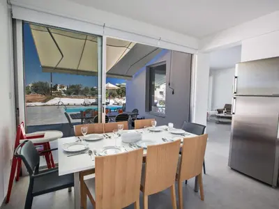 a dining room with a white table and chairs at Holiday Home Wunderschöne- geräumige Ferienvilla mit BBQ by Interhome in Protaras