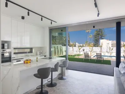 a kitchen with white counters and chairs and a large window at Holiday Home Protaras Aqua Pearl Villa AQ05 by Interhome in Protaras