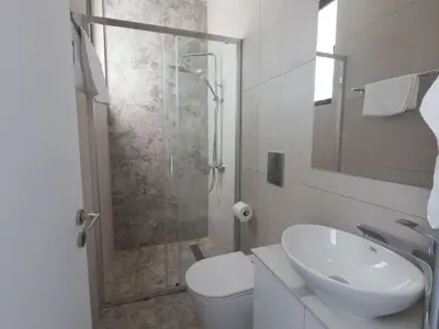 a bathroom with a shower and a toilet and a sink at Holiday Home Protaras Aqua Pearl Villa AQ05 by Interhome in Protaras