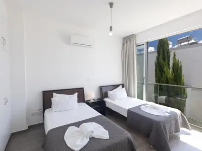a hotel room with two beds and a window at Holiday Home Greco Villa CCV4- 5-Schlafzimmer-Villa mit privatem Pool in Protaras Zentrum by Interhome in Protaras