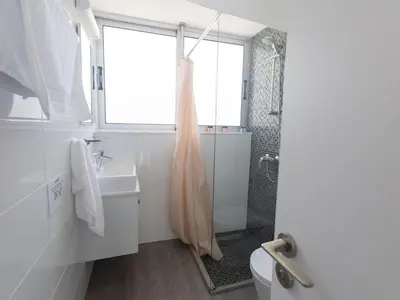 a white bathroom with a shower and a sink at Holiday Home Greco Villa CCV4- 5-Schlafzimmer-Villa mit privatem Pool in Protaras Zentrum by Interhome in Protaras