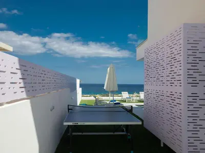 a table on a balcony with a view of the ocean at Holiday Home Eleganter Urlaub Artizan Villa AR5 by Interhome in Protaras
