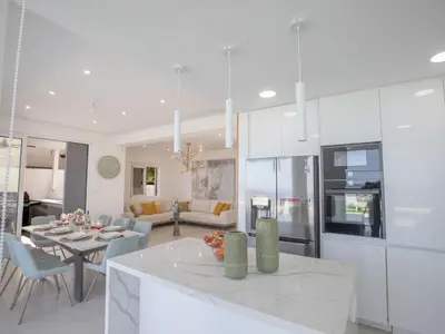 a white kitchen and living room with a table at Holiday Home Eleganter Urlaub Artizan Villa AR5 by Interhome in Protaras