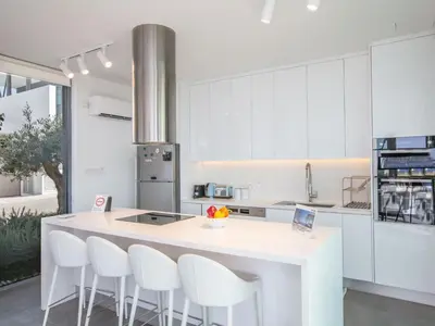 a kitchen with a white island with white chairs at Holiday Home Haus in Paralimni mit großem Patio by Interhome in Paralimni