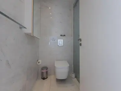 a white bathroom with a toilet and a sink at Apartment Luxuriöse Wohnung am Strand von Thalassa by Interhome in Protaras