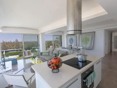 a kitchen and living room with a table with a bowl of fruit at Apartment Luxuriöse Wohnung am Strand von Thalassa by Interhome in Protaras