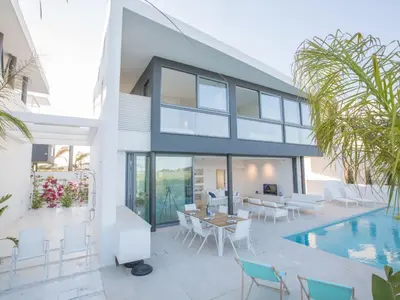 a house with a pool and a table and chairs at Holiday Home Neue- moderne 3-Schlafzimmer-Villa mit privatem Pool by Interhome in Paralimni