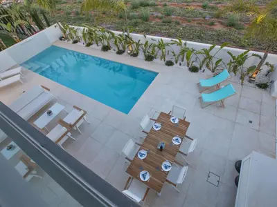 an overhead view of a pool with chairs and a table at Holiday Home Neue- moderne 3-Schlafzimmer-Villa mit privatem Pool by Interhome in Paralimni
