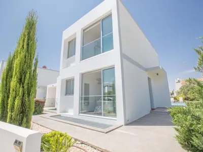 a white house with large windows and trees at Holiday Home Protaras Greco Villa CCV1 mit beheiztem Pool by Interhome in Protaras