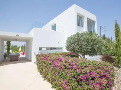 a white house with pink flowers in front of it at Holiday Home Protaras Greco Villa CCV1 mit beheiztem Pool by Interhome in Protaras