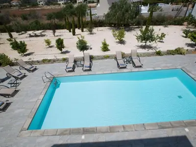an empty swimming pool with chairs and a beach at Holiday Home Protaras Greco Villa CCV1 mit beheiztem Pool by Interhome in Protaras