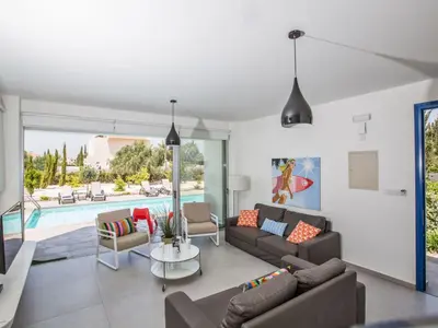 a living room with a couch and a table and a pool at Holiday Home Protaras Greco Villa CCV1 mit beheiztem Pool by Interhome in Protaras