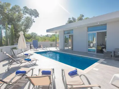 a patio with chairs and a swimming pool at Holiday Home Protaras - schönes Ferienhaus für 10 Personen by Interhome in Protaras