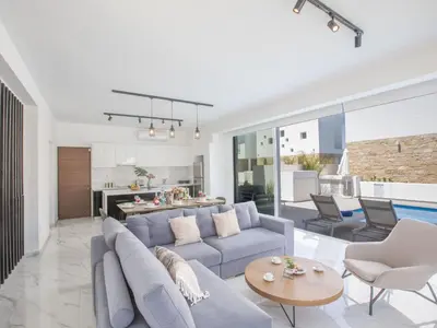 a living room with a blue couch and a table at Holiday Home Protaras Vie Bleu Villa VB5 by Interhome in Protaras