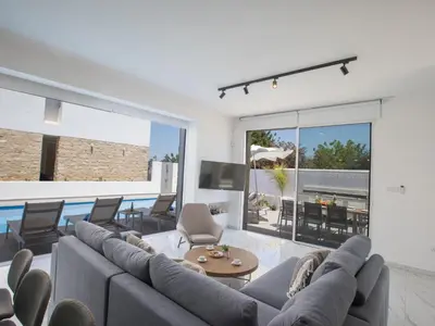 a living room with a large couch and a pool at Holiday Home Protaras Vie Bleu Villa VB5 by Interhome in Protaras