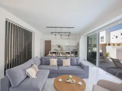 a living room with a blue couch and a table at Holiday Home Protaras Vie Bleu Villa VB5 by Interhome in Protaras