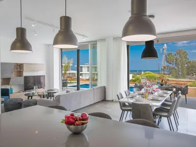 a dining room with tables and chairs and a fireplace at Holiday Home Ferienvilla Olivine Pearl mit Meerblick by Interhome in Protaras