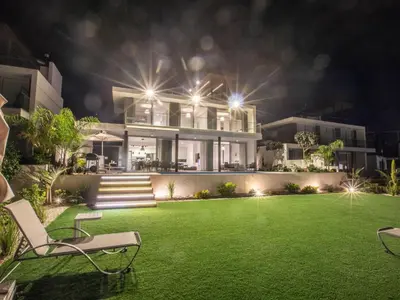 a house with a lawn in front of it at night at Holiday Home Ferienvilla Olivine Pearl mit Meerblick by Interhome in Protaras