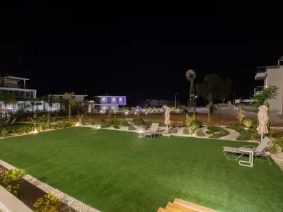 a yard with a green lawn at night at Holiday Home Ferienvilla Olivine Pearl mit Meerblick by Interhome in Protaras