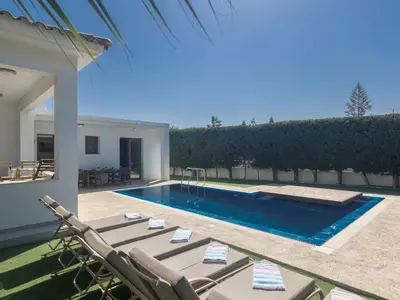 a swimming pool with lounge chairs next to a house at Holiday Home Ayia Napa Satin Villa SVI1 by Interhome in Ayia Napa