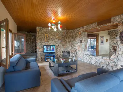 a living room with blue couches and a stone wall at Holiday Home Private Villa mit Panoramablick auf das Meer by Interhome in Protaras