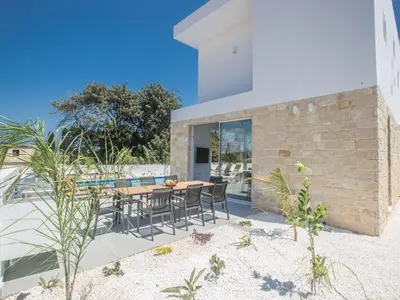 a house on the beach with a table and chairs at Holiday Home 4-Schlafzimmer-Villa mit Pool im Zentrum von Protaras by Interhome in Protaras