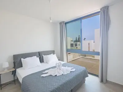 a bedroom with a bed with a white flower on it at Holiday Home Protaras Aqua Pearl Villa AQ11 im Zentrum by Interhome in Protaras