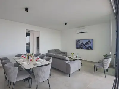 a living room with a couch and a table and chairs at Holiday Home Protaras Aqua Pearl Villa AQ11 im Zentrum by Interhome in Protaras
