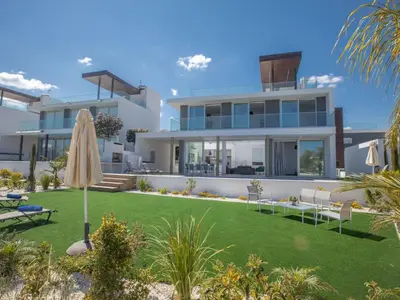 an image of a house with a lawn and an umbrella at Holiday Home Schöne Villa Olivine Pearl OL5 mit Garten by Interhome in Protaras