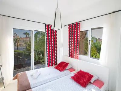 a bedroom with red and white curtains and a bed with red pillows at Holiday Home Charmante 3-Schlafzimmer-Villa DI12 mit privatem Pool by Interhome in Protaras