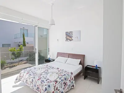 a bedroom with a bed and a balcony at Holiday Home Neue Ferienvilla für 10 Personen by Interhome in Protaras