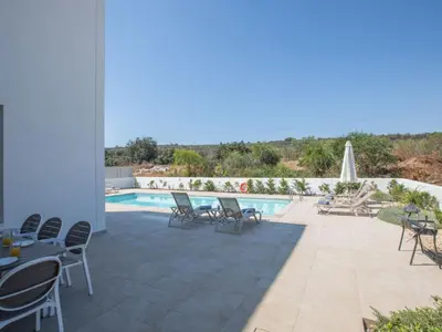 a patio with chairs and a swimming pool at Holiday Home Neue Ferienvilla für 10 Personen by Interhome in Protaras