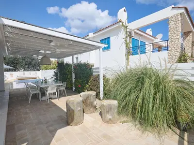 a patio with a table and chairs and a building at Holiday Home Protaras Serifos Villa SV7 100m vom Strand entfernt by Interhome in Paralimni