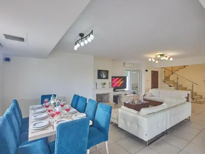 a living room with a table and blue chairs at Holiday Home Protaras Serifos Villa SV7 100m vom Strand entfernt by Interhome in Paralimni